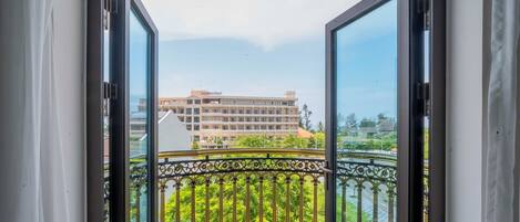 A balcony with ornate black railings and a view of a building labeled "Dresden Hotel Resort."