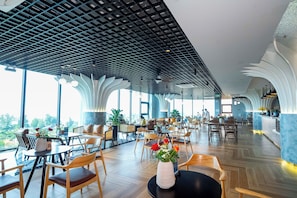 A spacious indoor area with high ceilings, modern lighting fixtures, and a mix of seating arrangements.