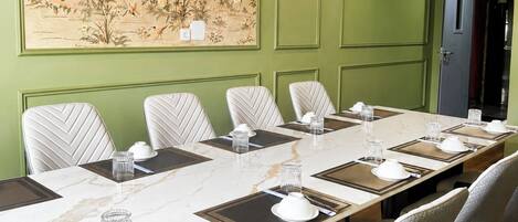 A conference room with a long table, chairs, and a ceiling fan.