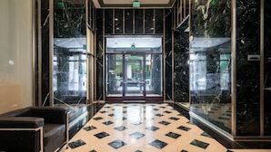 A lobby with a marble floor, glass doors, and a car parked outside. - Luxury Downtown Phoenix Loft - Pool Gym Laundry (Phoenix)