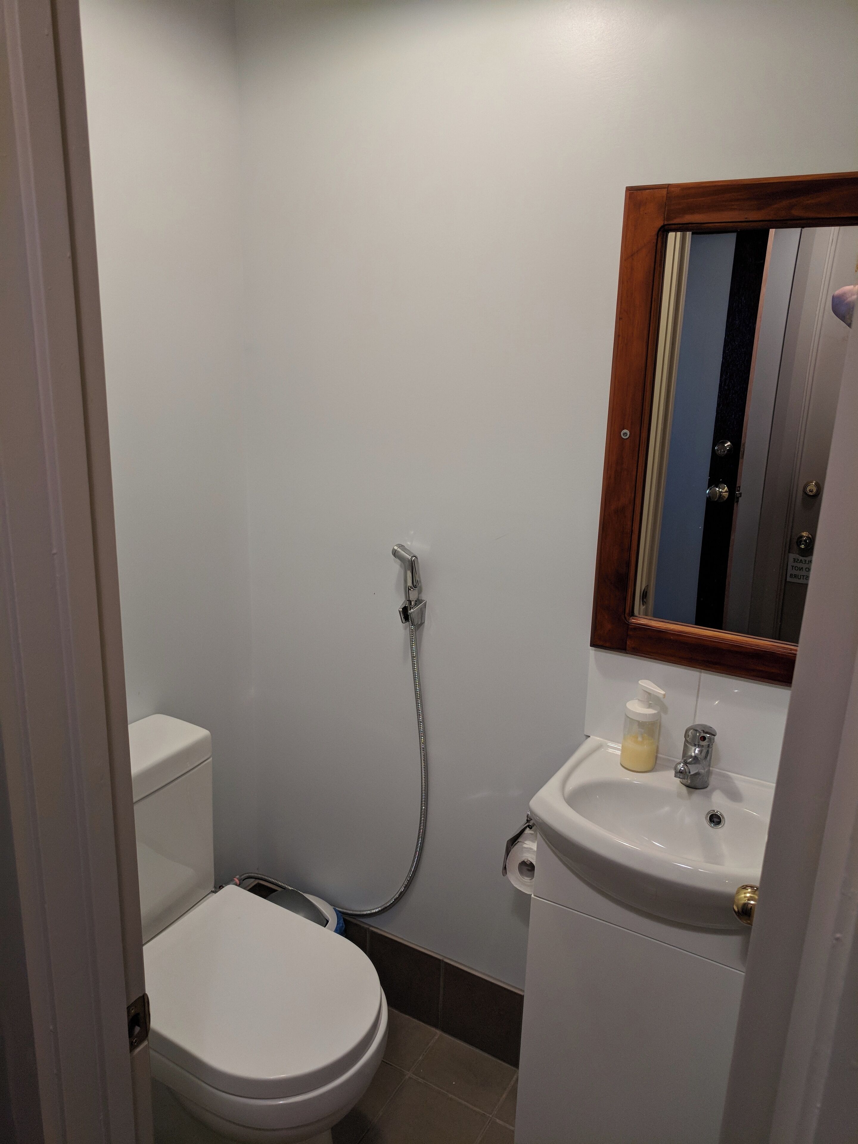 Un baño pequeño y funcional con inodoro, lavamanos y ducha.