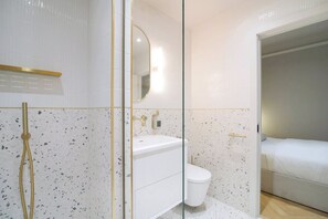 A modern bathroom with a glass partition, a white sink, and a toilet. - Blanco | The Heim (Greater Manchester)