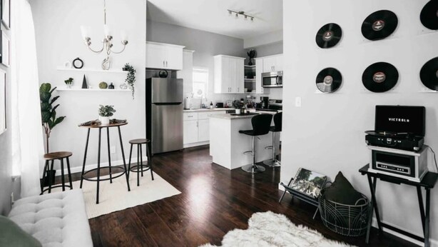 A modern kitchen with white cabinets, a stainless steel refrigerator, and a bar area with stools. - Spacious 3BR Sleeps 8/Perfect for Groups (San Antonio)