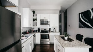 A modern kitchen with white cabinets, stainless steel appliances, and a granite countertop. - Spacious 3BR Sleeps 8/Perfect for Groups (San Antonio)
