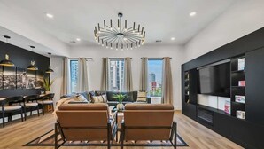 A modern living room with a sofa set, a coffee table, and a TV unit. - Music Row - Luxury Home w/ 5 en-suites! (Nashville)