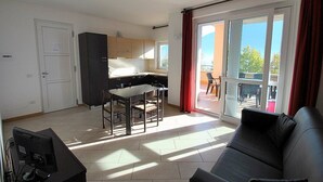 A modern apartment with a kitchen, dining area, and a balcony.