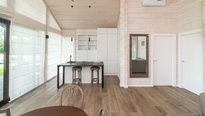 Un'ampia cucina con isola centrale, pavimento in legno e luci a sospensione.