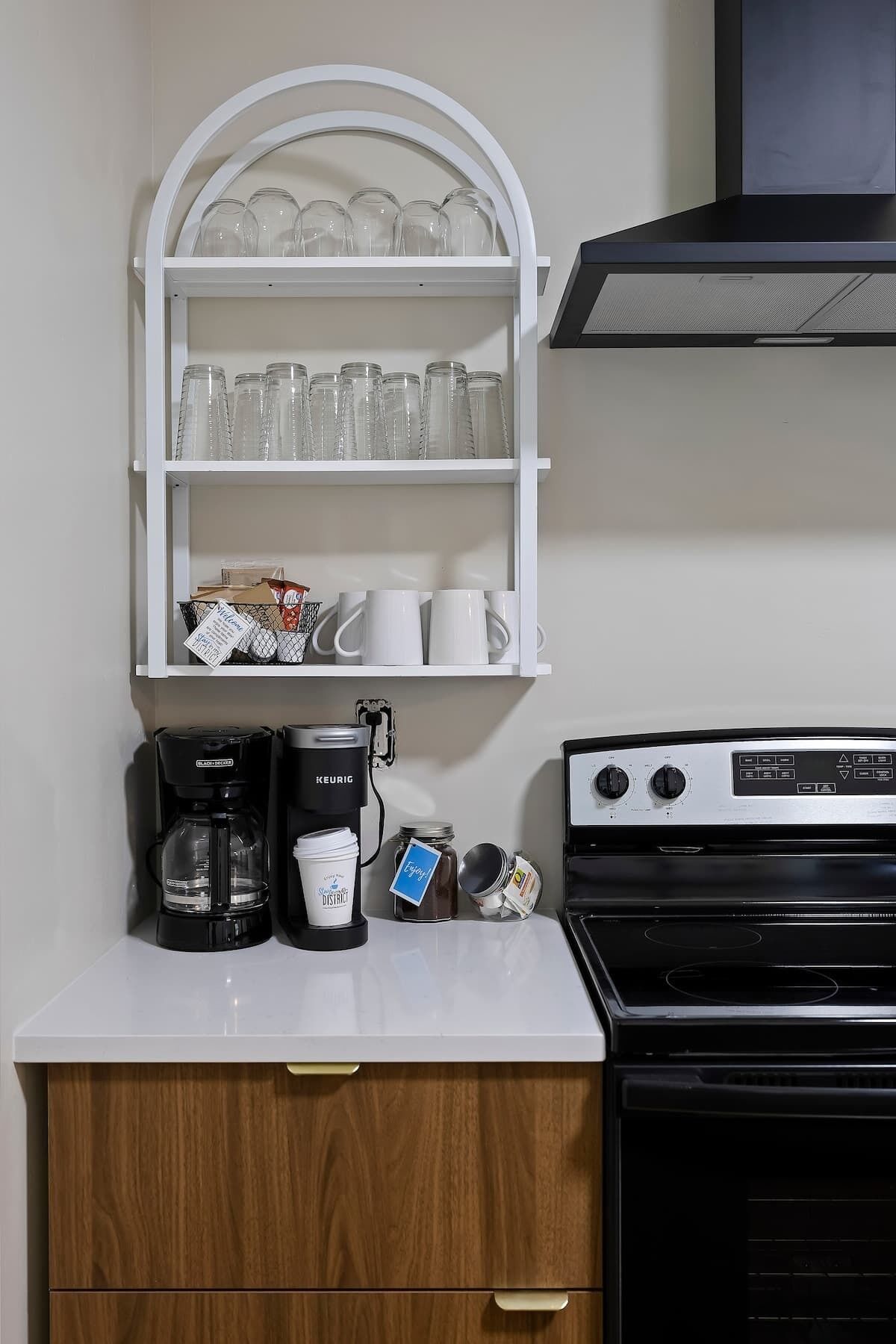 Une petite cuisine équipée d’une machine à café, d’une bouilloire et d’un pot à sucre.
