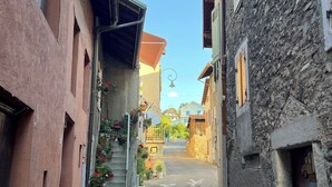 Una stretta via fiancheggiata da edifici, con una scala che conduce verso l'alto e un cielo sereno.
