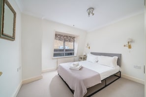 2 habitaciones, escritorio y tabla de planchar con plancha