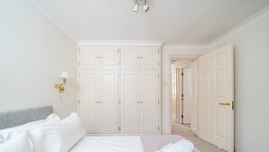 A hotel room with a large bed, a wardrobe, and a bathroom door.