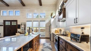 Une cuisine spacieuse avec des meubles en bois, un plan de travail en marbre et un grand îlot central.