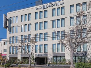 A modern hotel building with a sign reading "MONDAY" and a visible entrance.
