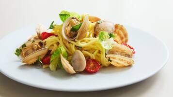 A plate of spaghetti with clams and cherry tomatoes.