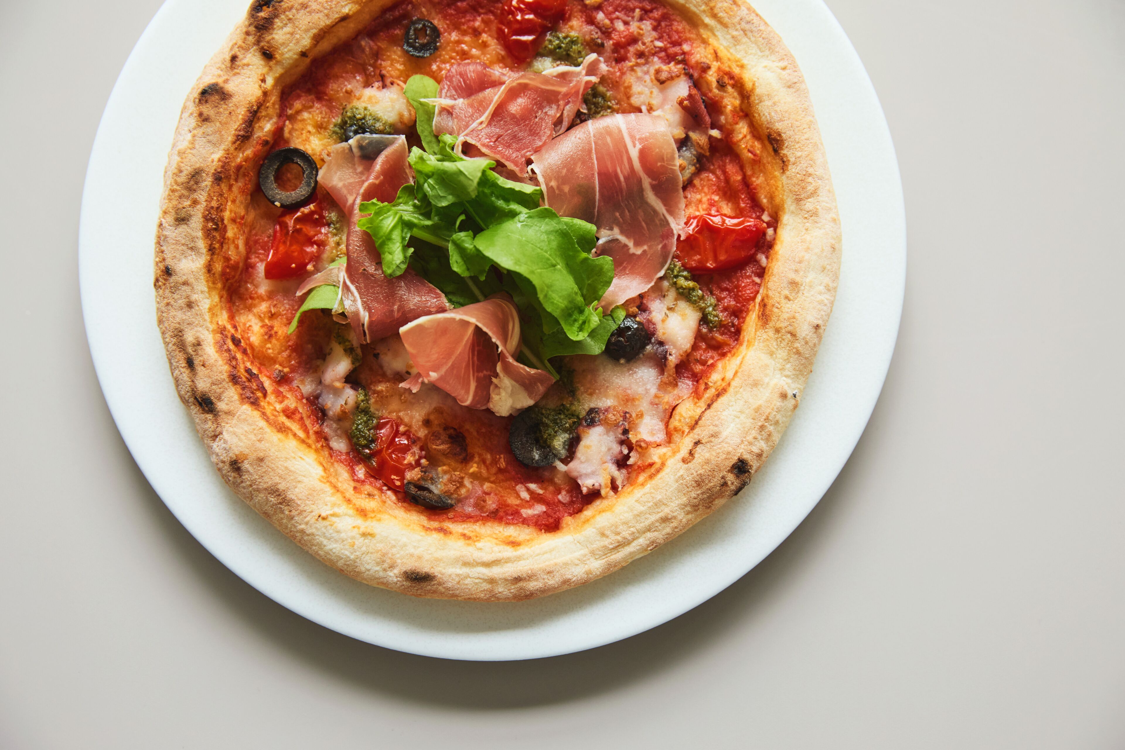A pizza with toppings on a white plate.