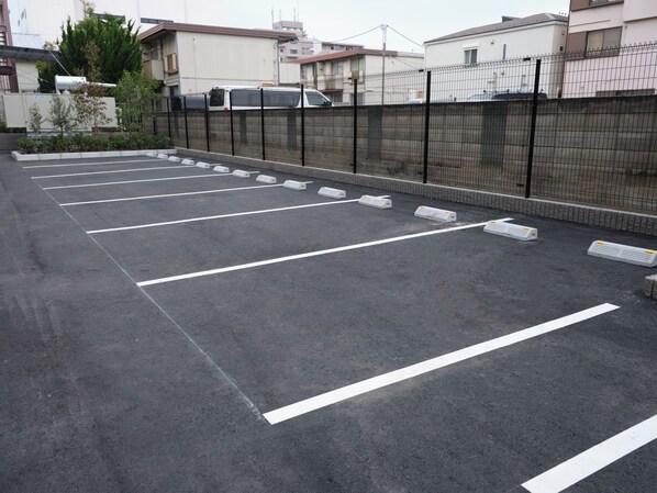 Un estacionamiento con espacios delimitados y una valla de metal negro.