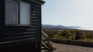 A cabin with a large window overlooking a scenic landscape.