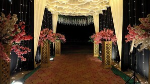 Un espace intérieur doté d’un sol recouvert de moquette, agrémenté de compositions florales décoratives et de rideaux drapés.