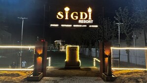 L’entrée du Sigdi Resort est signalée par un panneau indiquant qu’il propose un espace pour les banquets, un restaurant, une pelouse pour les cérémonies de mariage et des chambres climatisées.