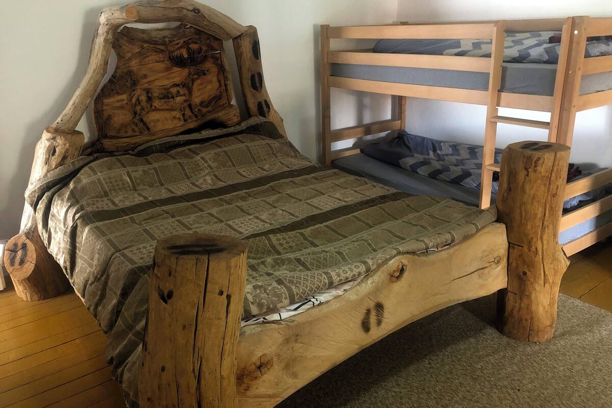 Ein hölzernes Bett mit geschnitztem Kopfteil und einem Schlafkoje-Aufbau.