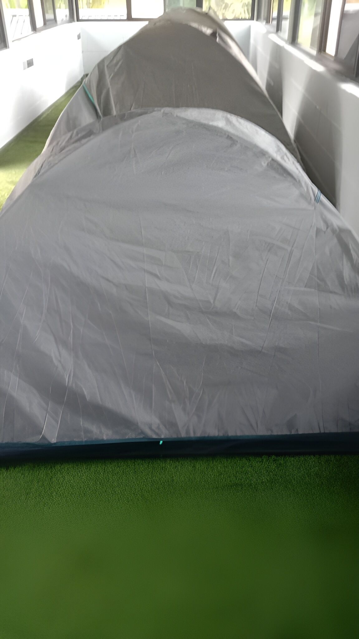 A bed with a grey mattress and a green base.
