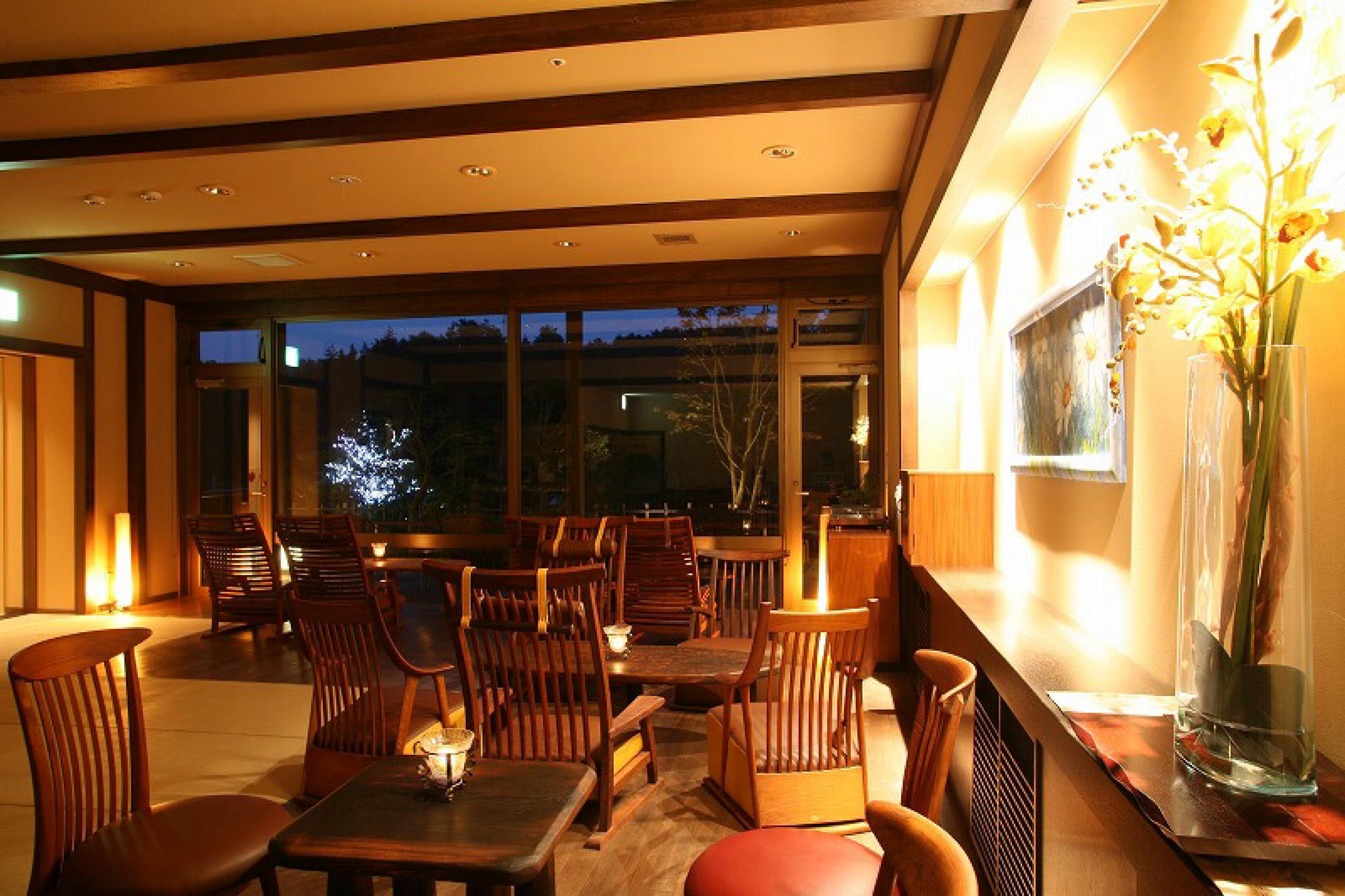 A dining area with wooden furniture and large windows.