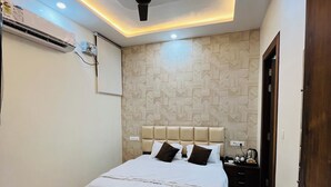 Un dormitorio moderno con cama, ventilador de techo, luces empotradas y pared con diseño.