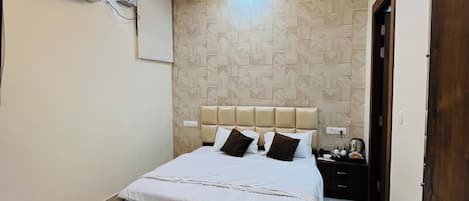 A modern bedroom with a bed, ceiling fan, recessed lighting, and a patterned wall.