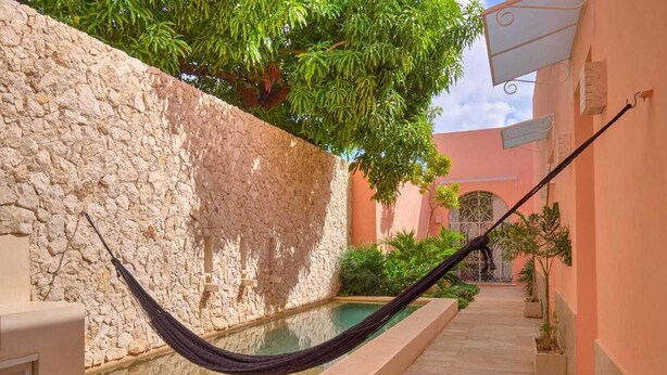 A narrow courtyard with a stone wall, a hammock, and a small pool. - CASA DE LOS PLATOS, IN THE HEART OF MÉRIDA (Centro)