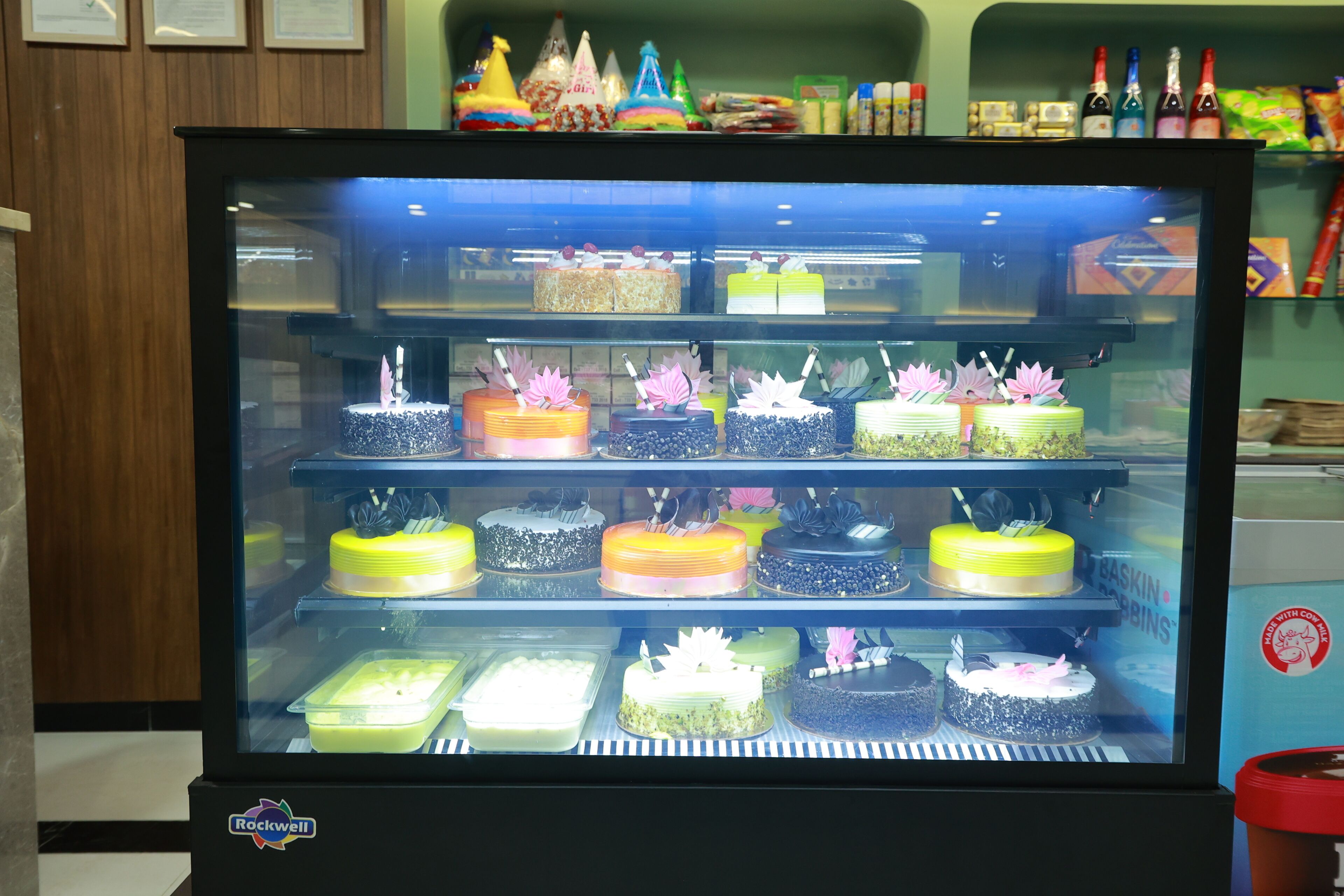 Vitrine com diversos bolos e sobremesas.