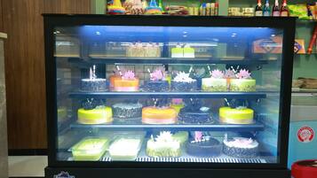 Vitrine com diversos bolos e sobremesas.