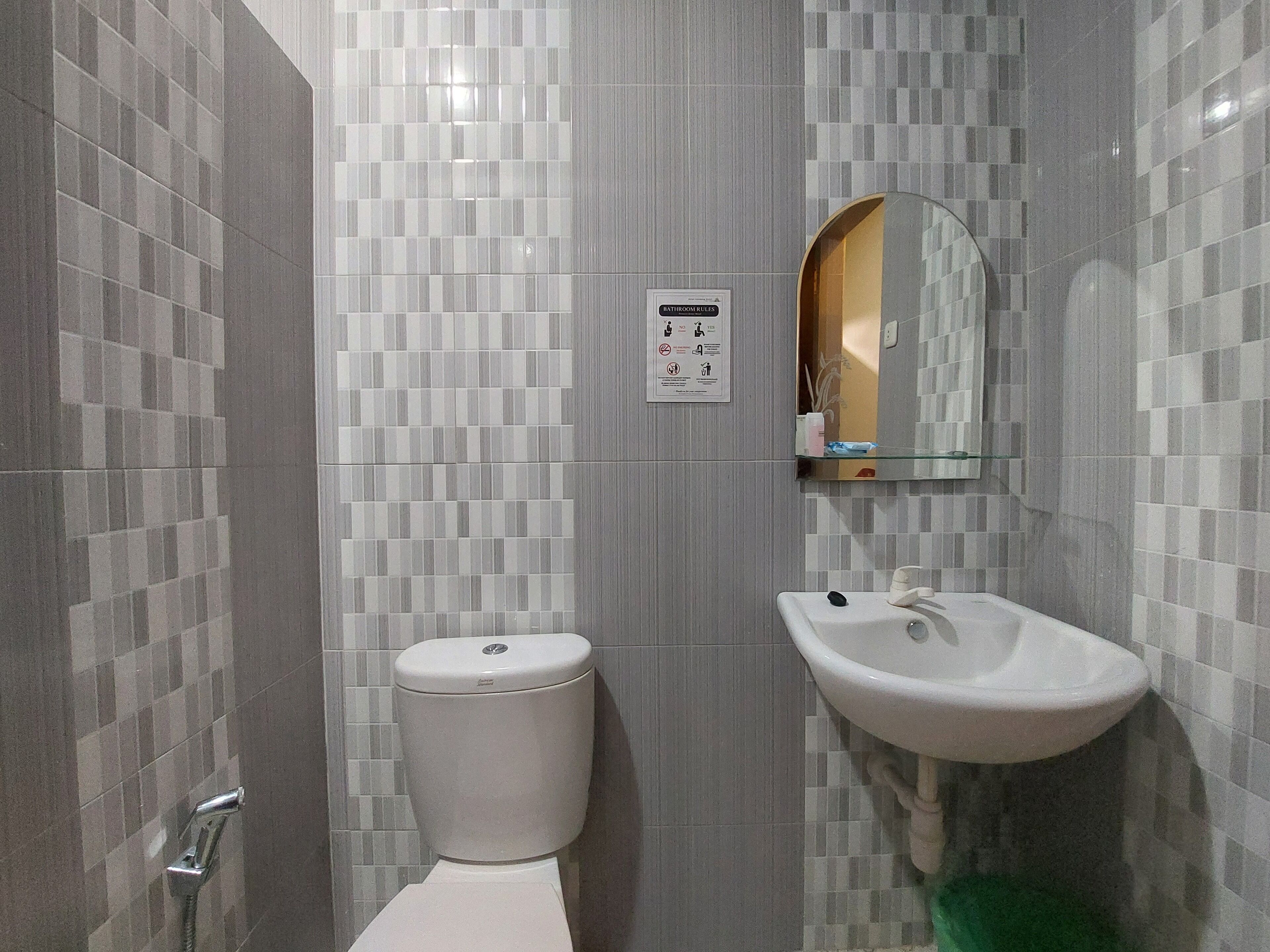 A modern bathroom with a toilet, sink, and a mirror.