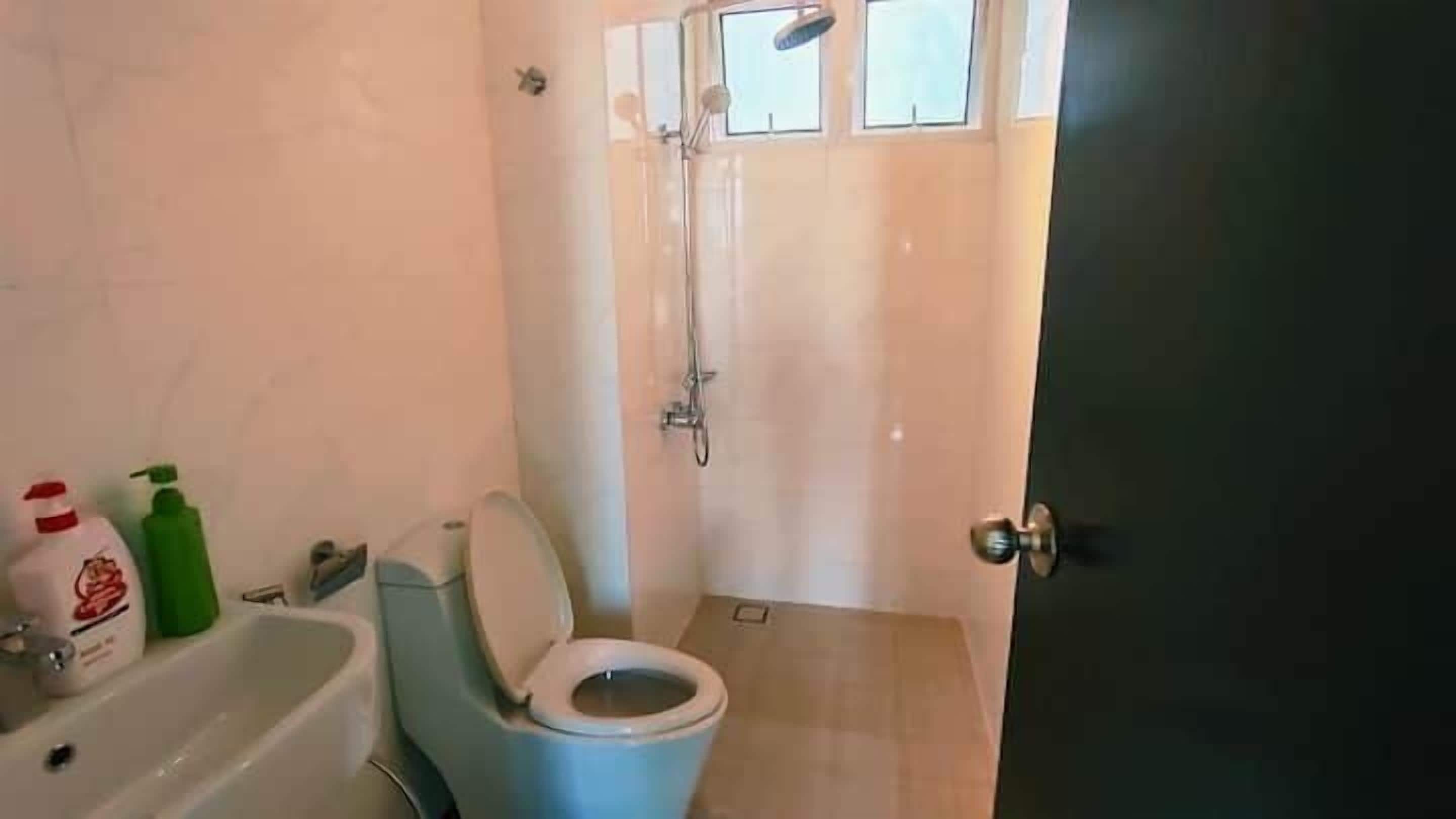 A bathroom with a toilet, a sink, and a shower.