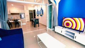 A modern living room with a large TV, a dining area, and a kitchen in the background. - Twin Galaxy (Johor Bahru)