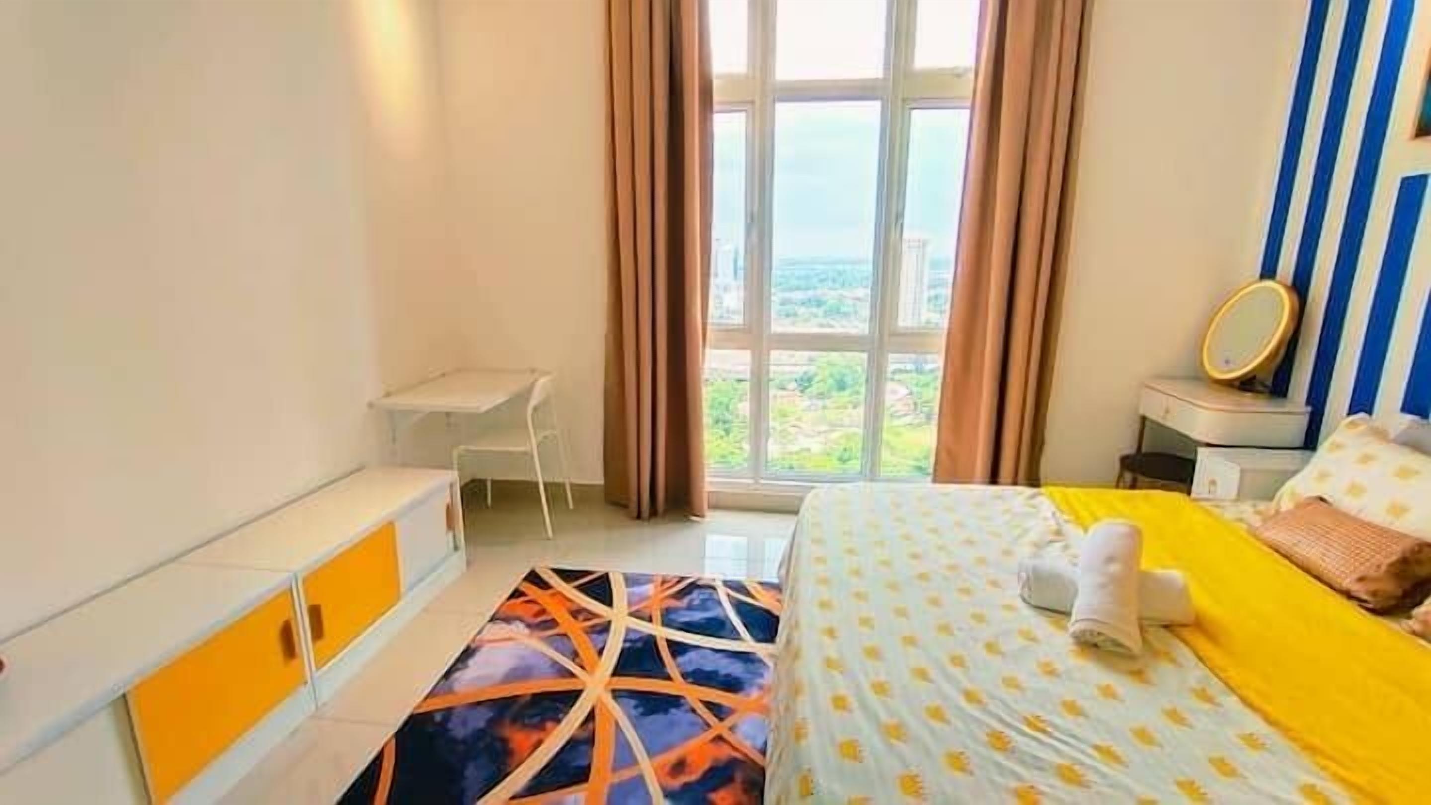 Una habitación de hotel con cama, escritorio y ventana con cortinas.