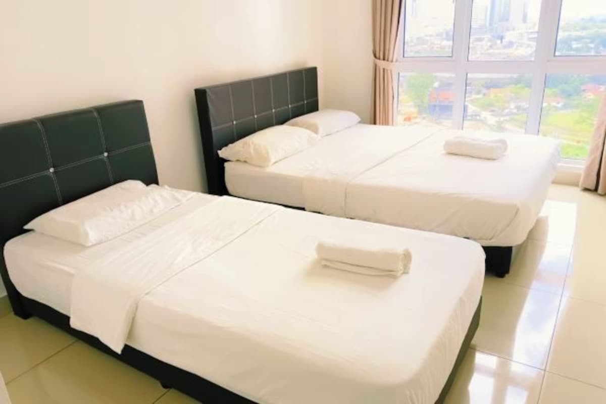Two twin beds with white linens and headboards, a large window with a view of buildings, and a tiled floor.