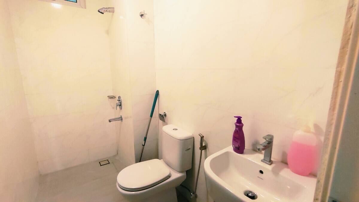 A small bathroom with a toilet, a sink, and a shower.
