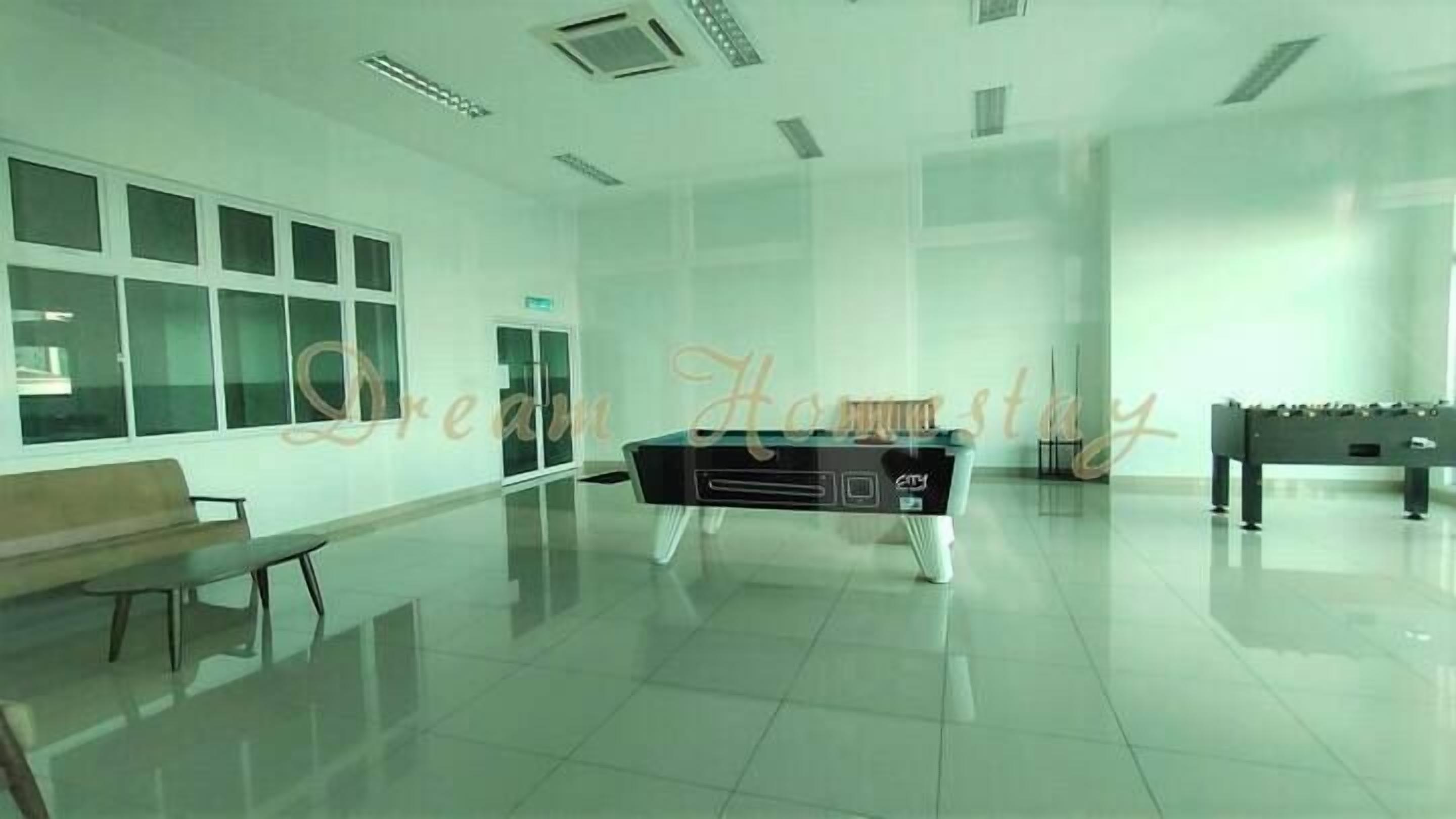 A spacious room with a pool table, a bench, and a foosball table.