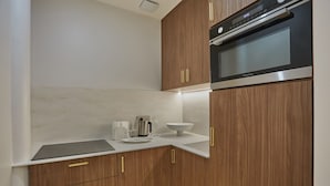 A modern kitchen with wooden cabinets, a built-in oven, and a white countertop. - Superb AC Apartment Roosevelt Saint Honore (Paris)