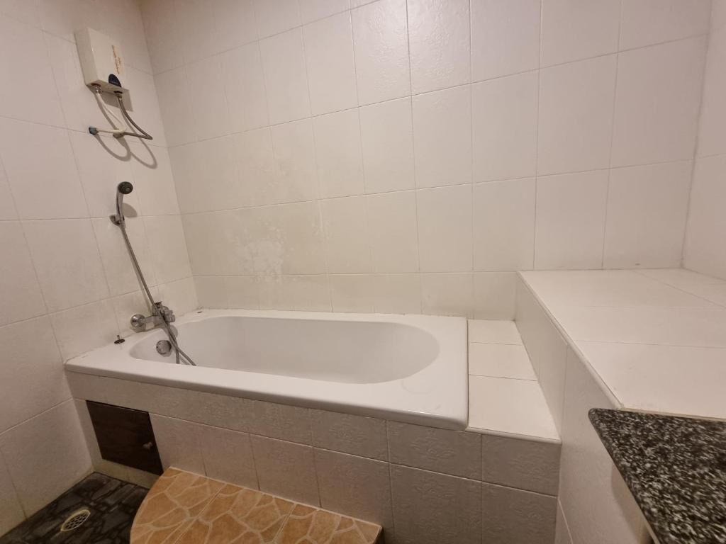 Un bany amb banyera, dutxa i vàter.