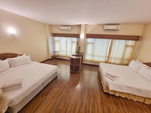 Habitación de hotel con dos camas, una mesita y una silla.