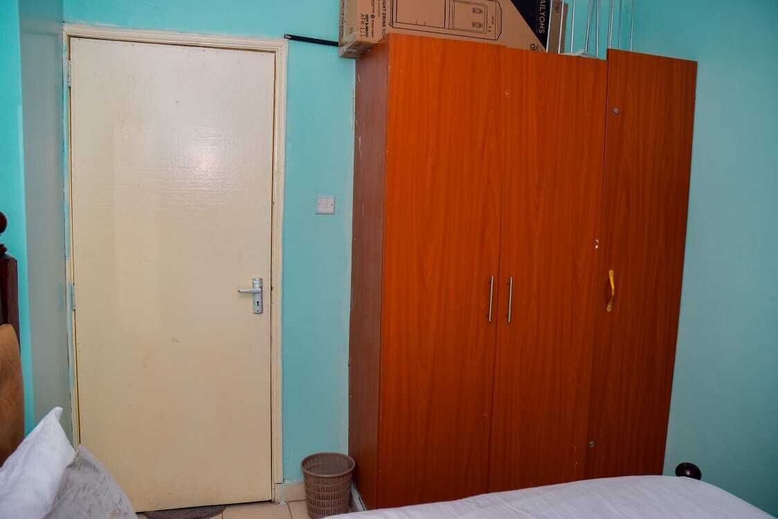 A bedroom with a bed, a wardrobe, and a door.
