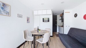 A compact living space with a dining area, a sofa, and a kitchenette. - Apartment Brelin by Interhome (Les Menuires)