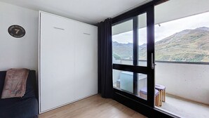 A room with a large sliding door leading to a balcony with a mountain view. - Apartment Brelin by Interhome (Les Menuires)