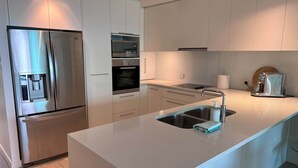 A modern kitchen with stainless steel appliances, a central island with a sink, and ample counter space.