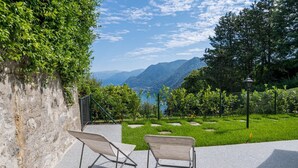 Due sedie con struttura in metallo e vista sulle montagne e un lago.