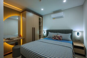 A modern bedroom with a large bed, bedside tables, a wardrobe, and a built-in bench. - Ayaz Suites (Bodrum)