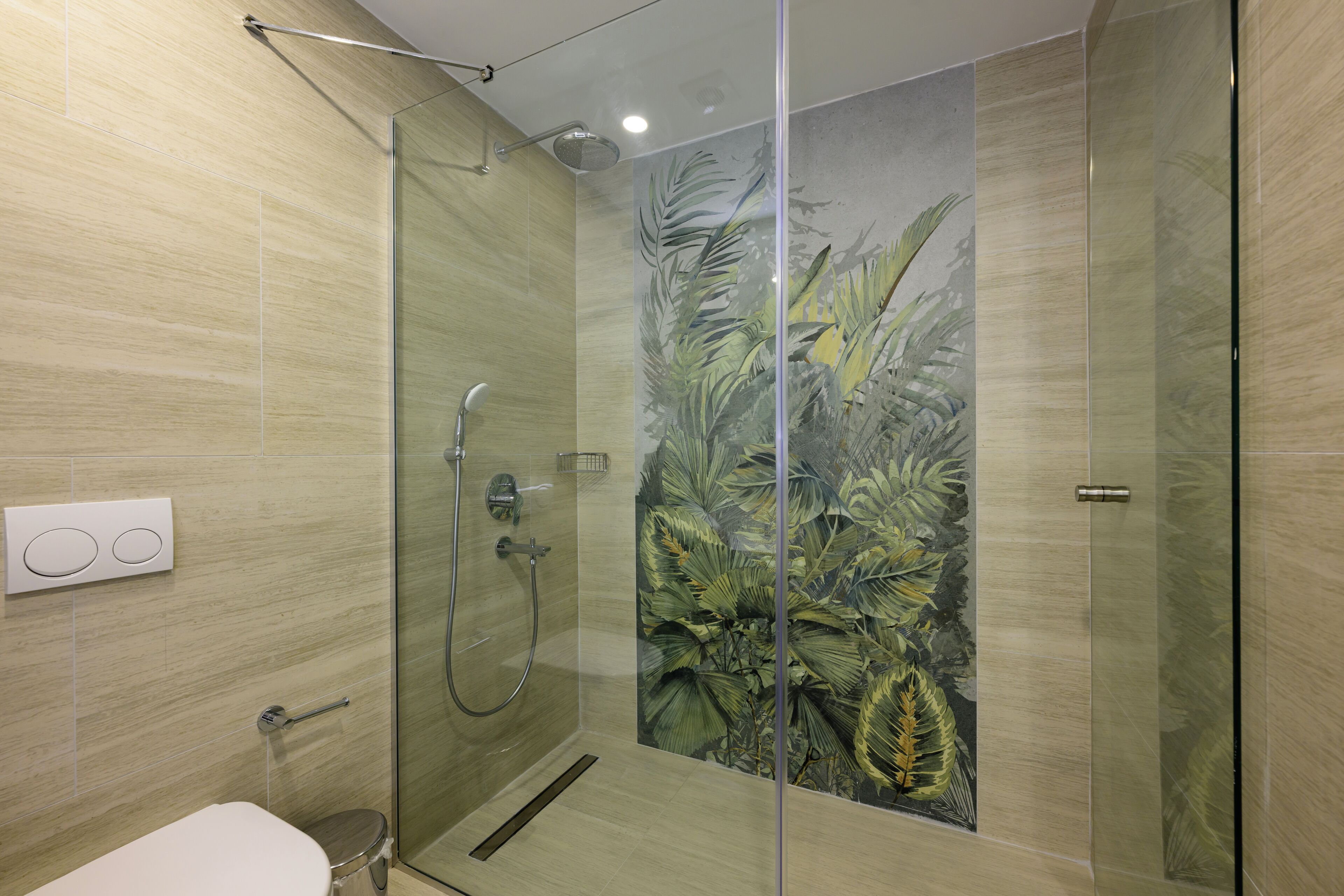 Un baño moderno con cabina de ducha de vidrio, inodoro y toallero de pared.