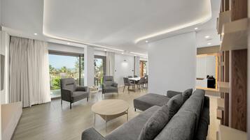 A modern living room with a sofa, armchairs, and a dining area.