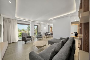 A modern living room with a sofa, armchairs, and a dining area. - Ayaz Suites (Bodrum)